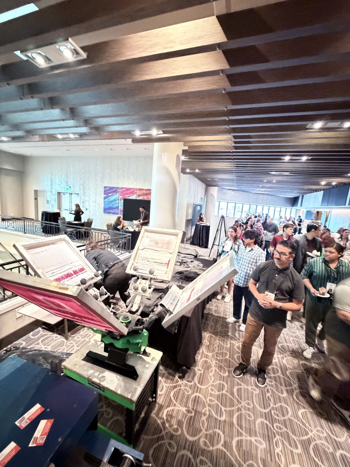 Guests waiting at a customization table inside a hotel ballroom event