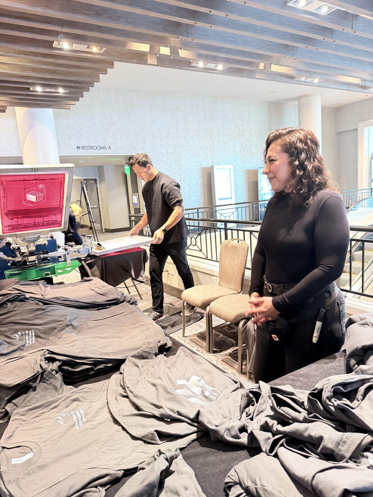 Merch Troop crew preparing garments during load-in at a hotel mezzanine